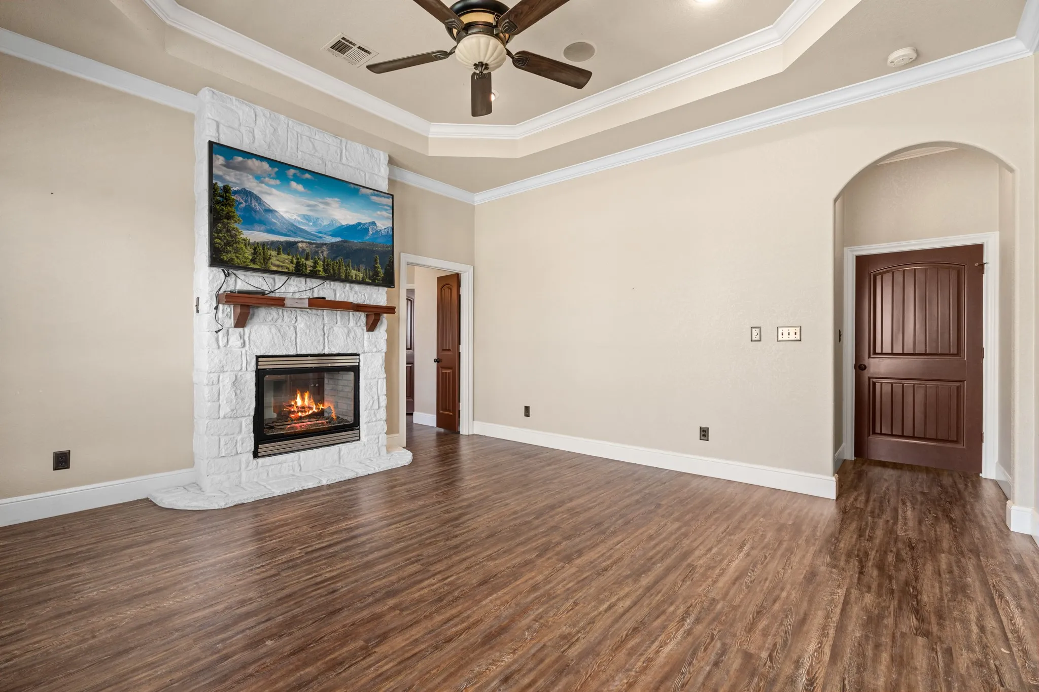 Primary suite with doubled sided fireplace into ensuite with raised celings.  Fire is photoshopped.