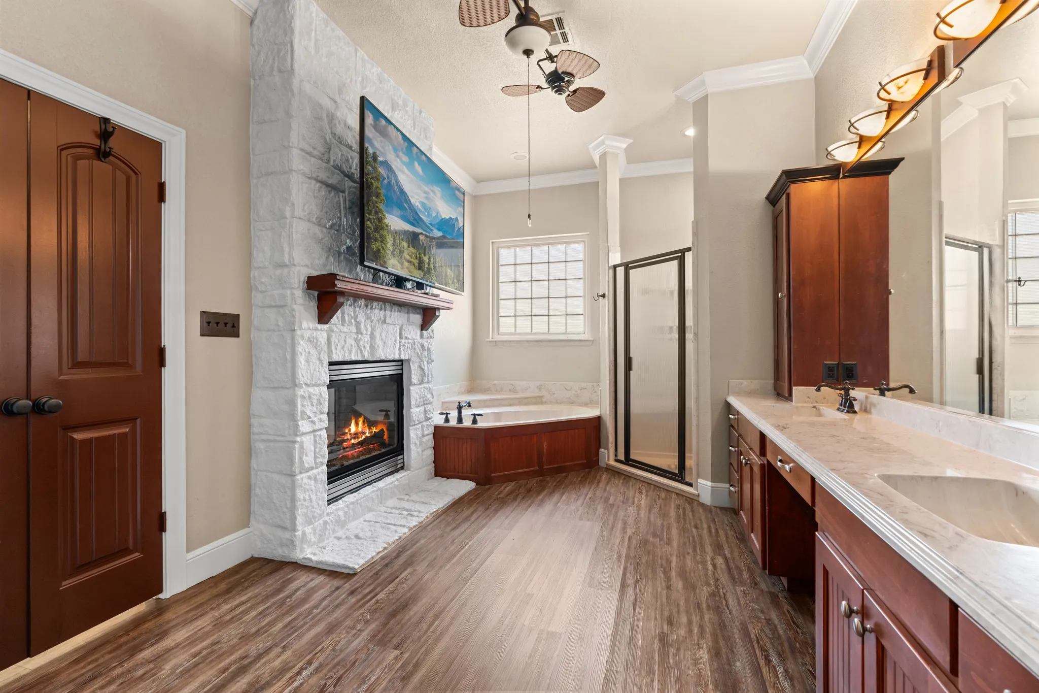 Primary ensuite bathroom with double sided fireplace connecting to primary bedroom.  Fire is photoshopped.
