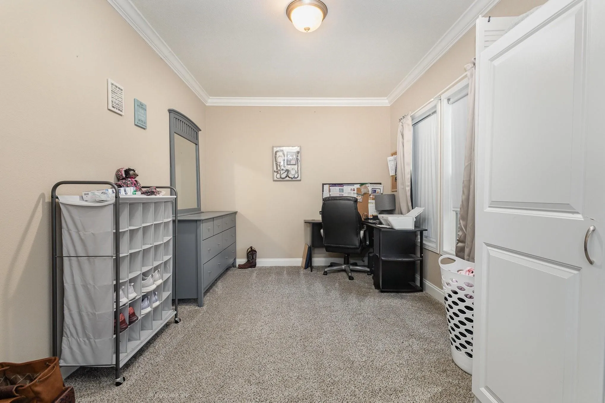 Carpeted room with neutral painted walls and white crown molding