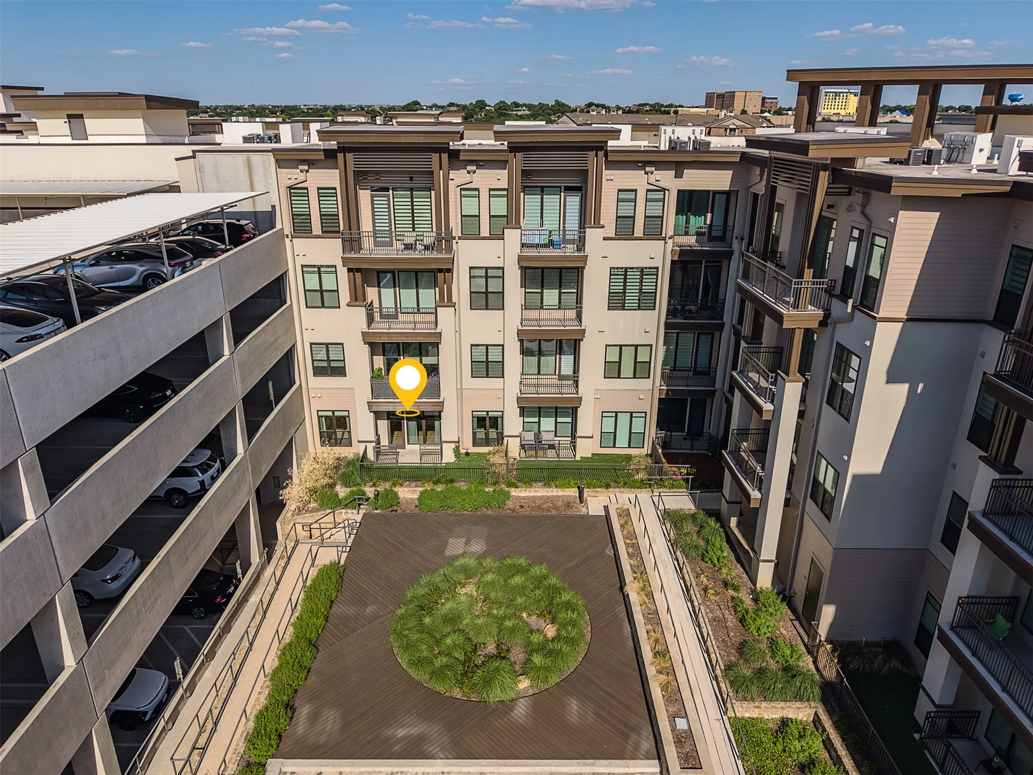 Modern multi-story building featuring multiple balconies and a ground-floor patio