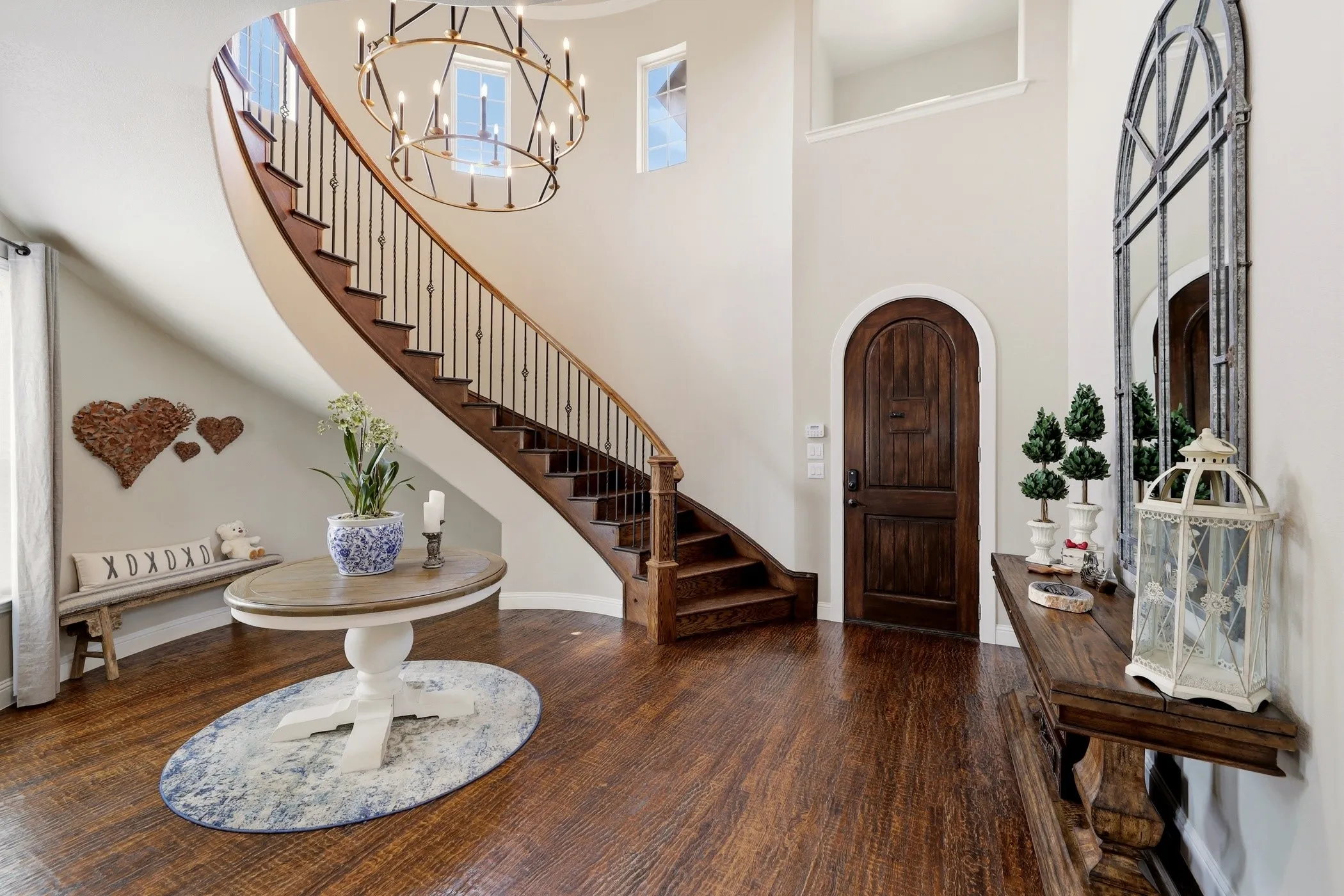 Elegant curved staircase in entry.  Expansive hardwood floors.  And, look at that elegant wood arched front door!