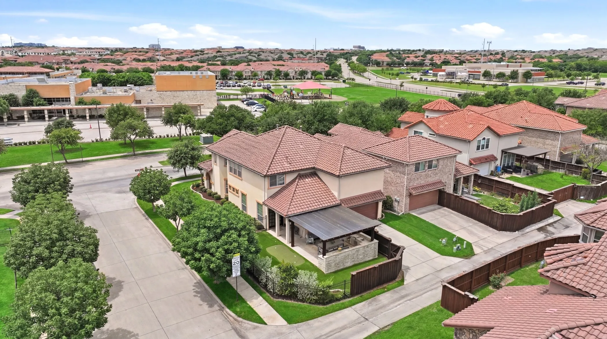 Rear entry garage, putting green, and large covered patio with outdoor kitchen.