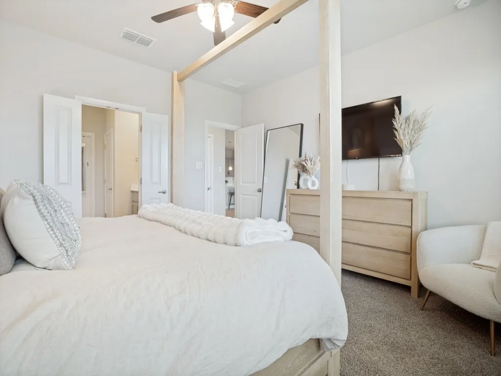 Carpeted room with a ceiling fan, light-toned walls, and white panel doors