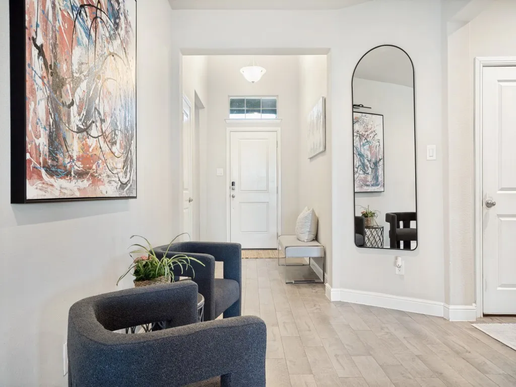 Spacious entryway featuring light wood-finish flooring, white baseboards, and neutral wall tones