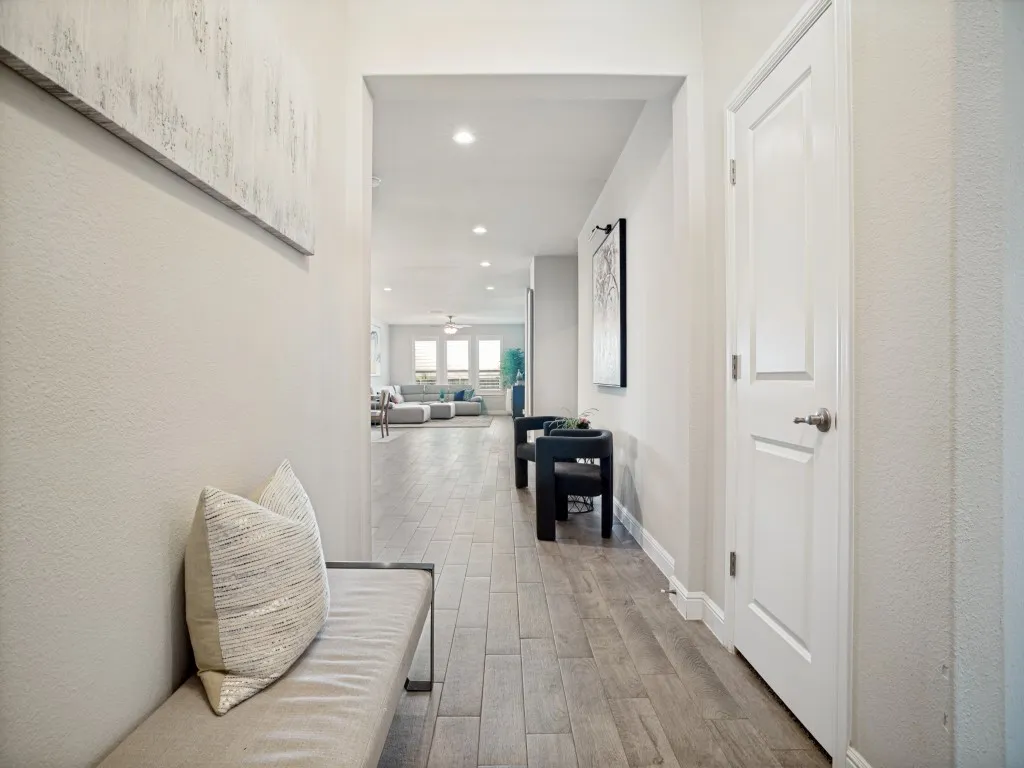 Entryway featuring wood-finish flooring, recessed lighting, and a white paneled door