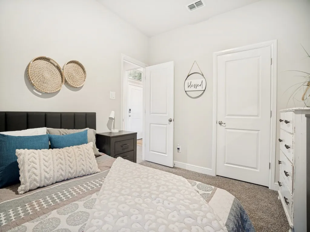 Bedroom featuring light-toned walls and plush carpeting