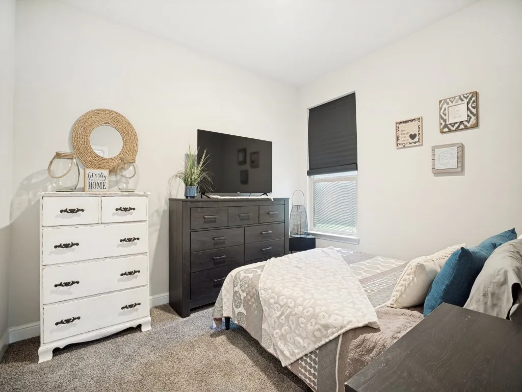 Plush carpet flooring complements neutral wall tones within this private room