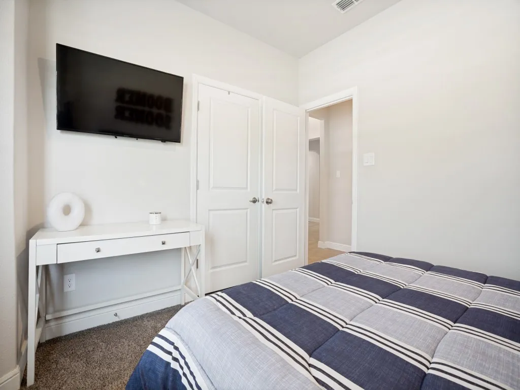 Neutral wall finishes with crisp white trim, plush carpeted flooring, and a ceiling-mounted air vent