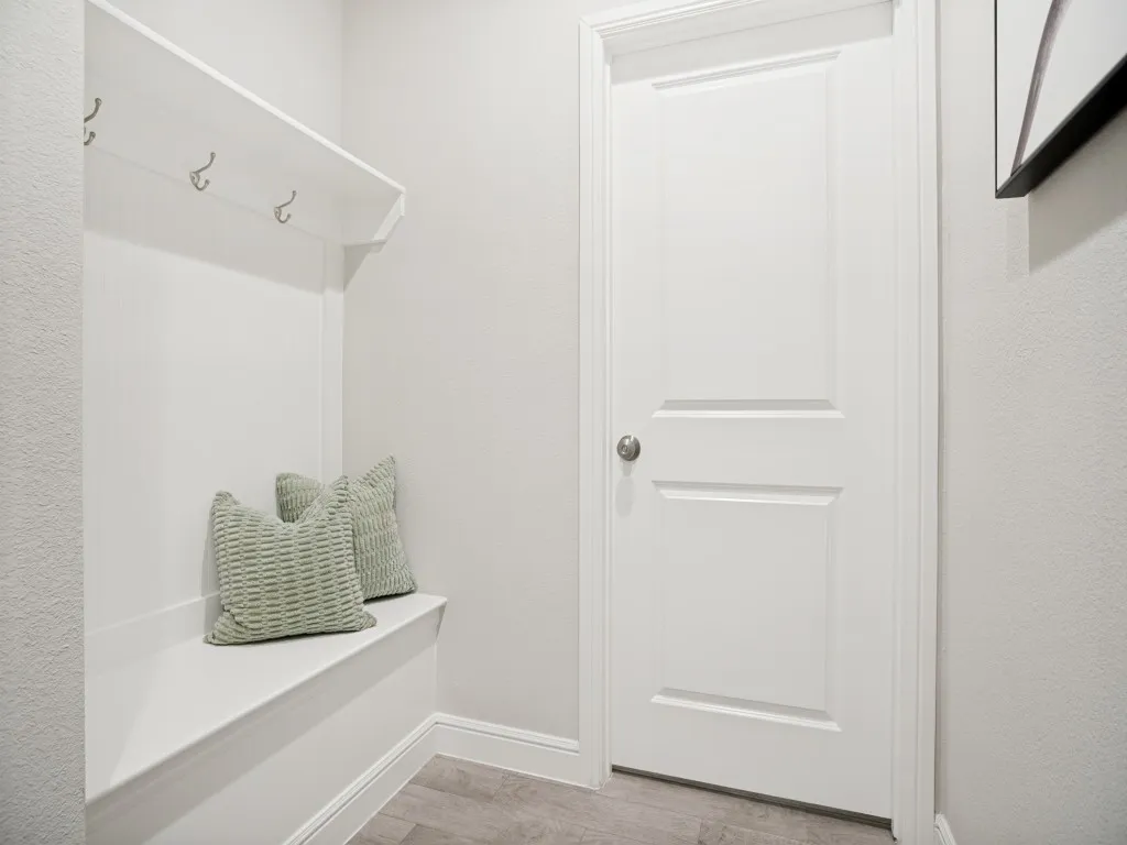 Built-in bench with upper shelving and coat hooks, complemented by wood-finish flooring