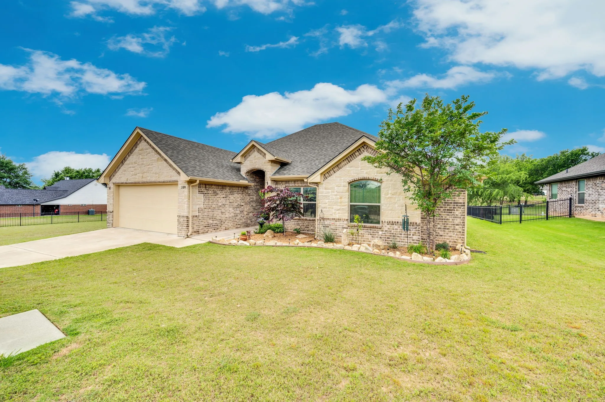 Charming side view of the front elevation, showcasing stone accents and mature landscaping.