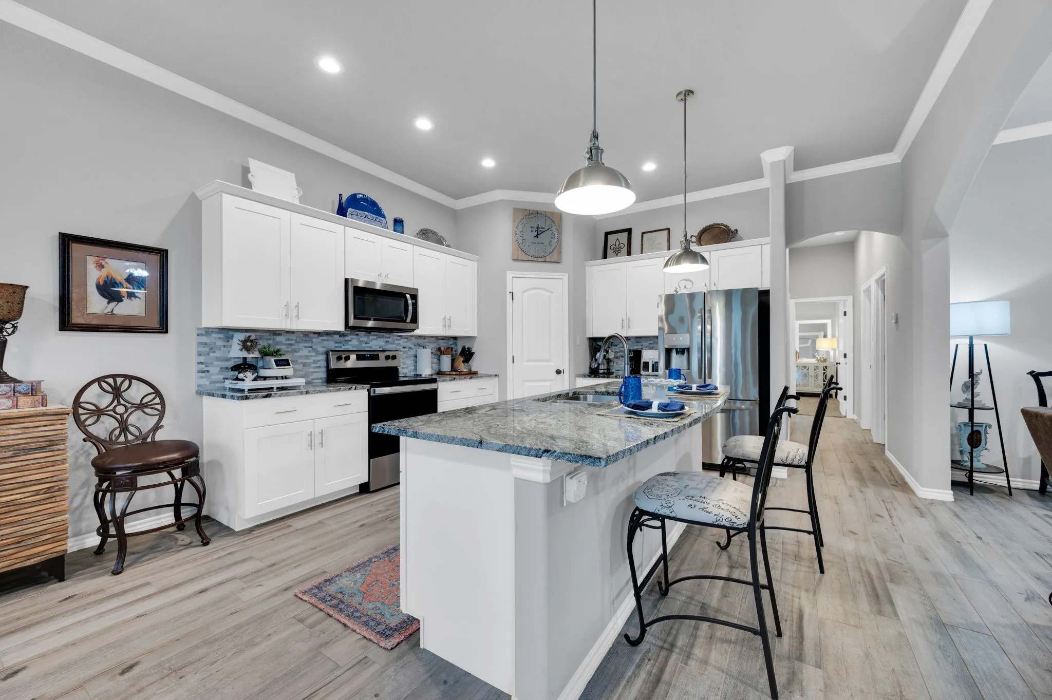 Stunning kitchen featuring crisp white cabinetry, a large island, and a tile backsplash, a dream space for any home chef.
