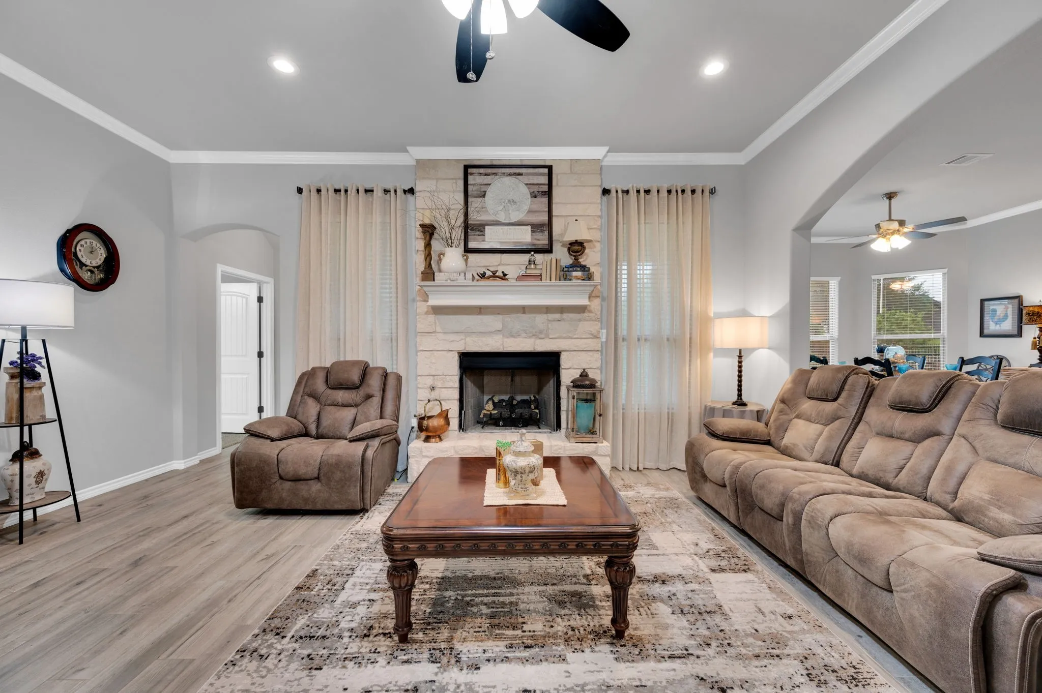 Inviting living room centered around a cozy fireplace with a stone surround, the heart of the home.