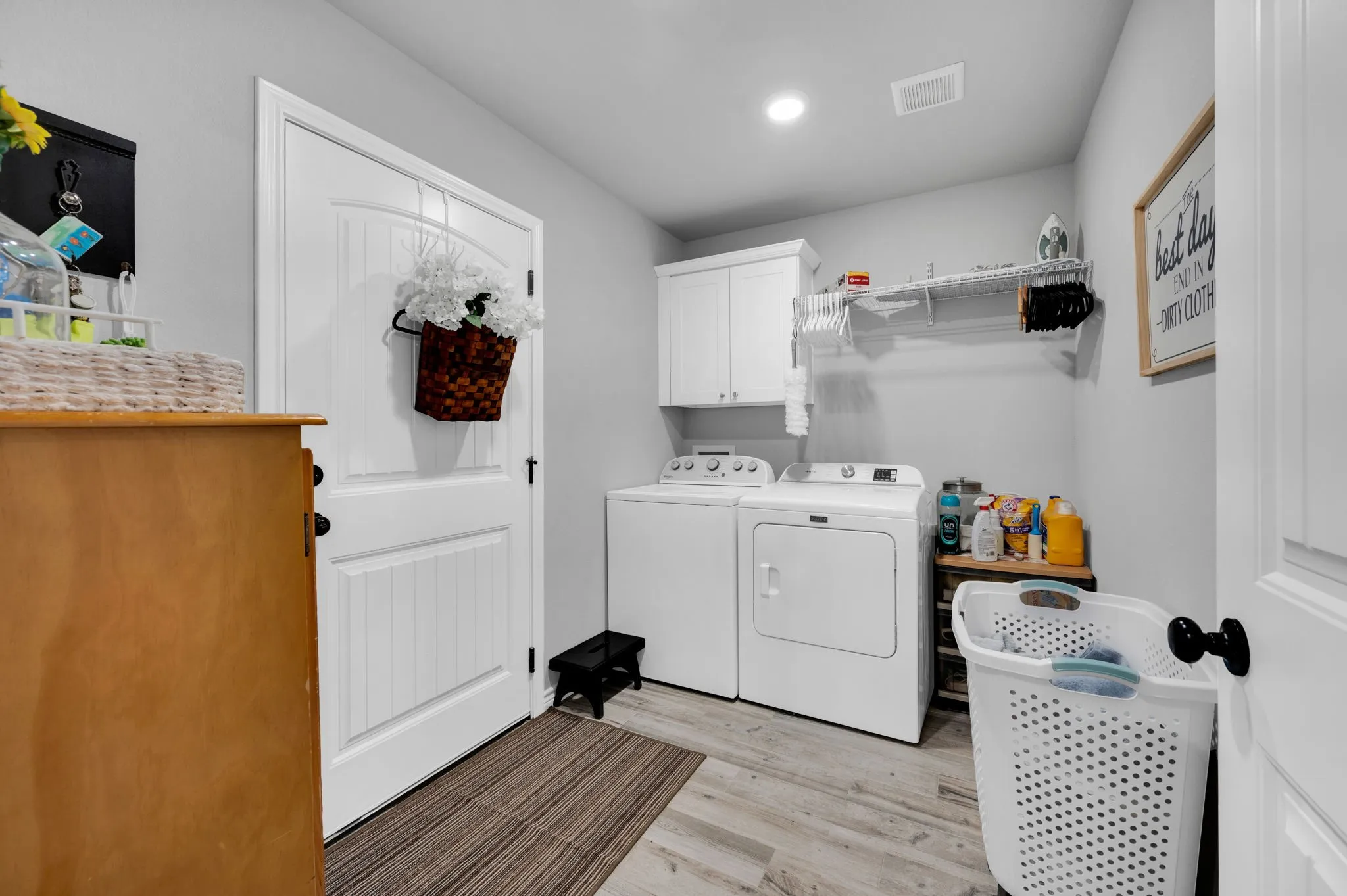 Convenient laundry room with built-in cabinetry for extra storage.