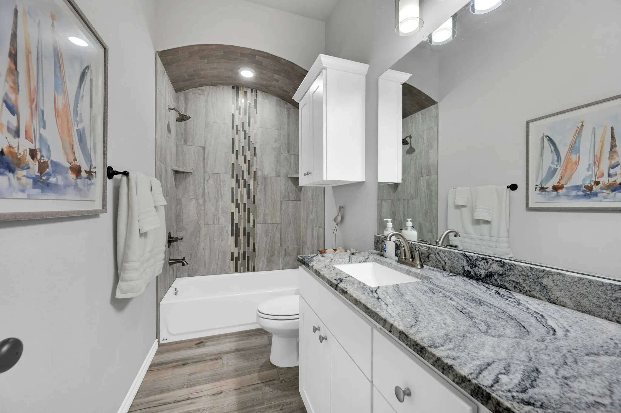 Second bathroom featuring a beautifully tiled walk-in shower with an arched niche.