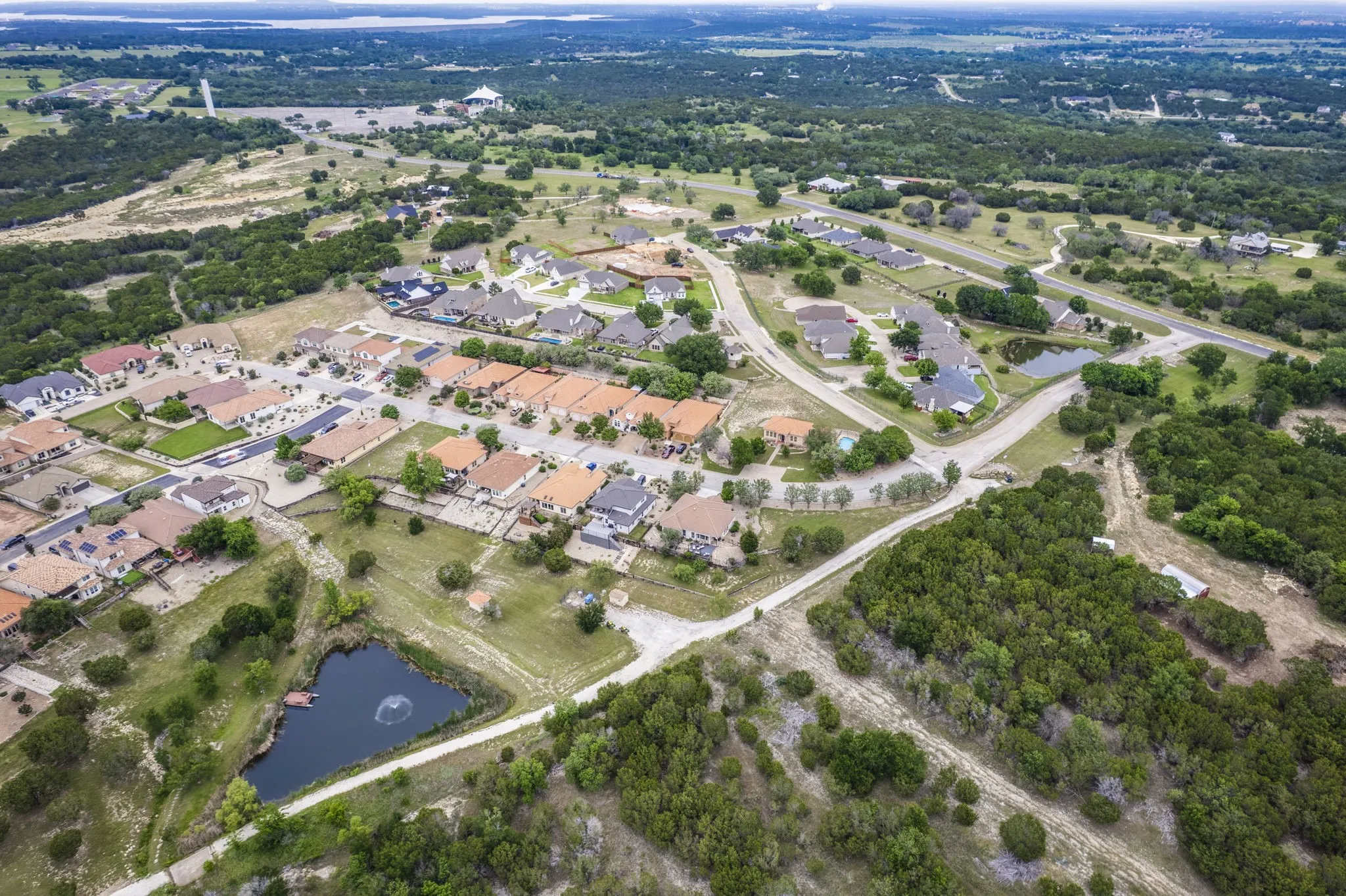 Aerial view highlighting the desirable neighborhood setting, complete with a community pond and green space.