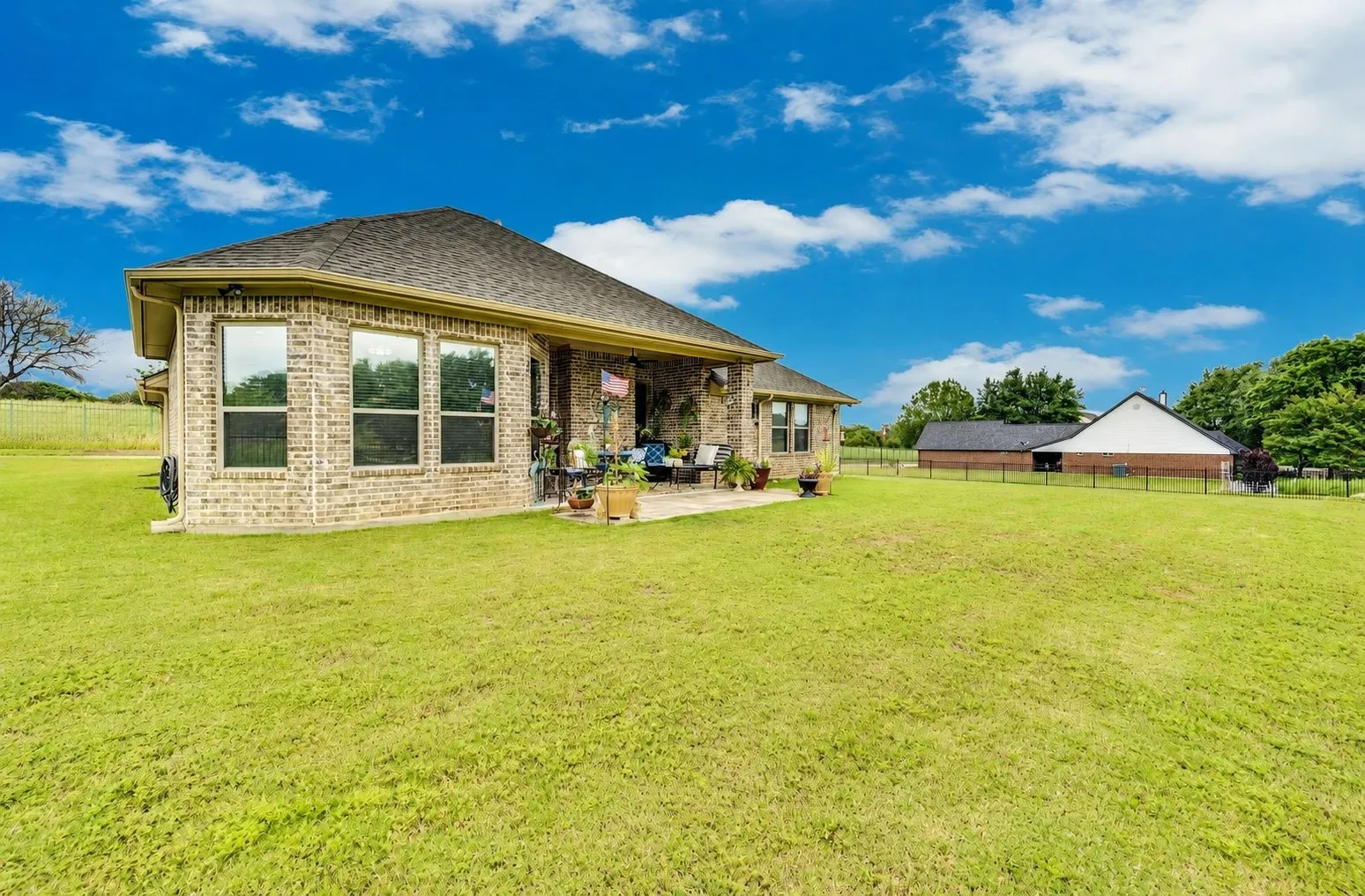 Side view of the backyard showcasing the home's stone exterior and expansive yard.