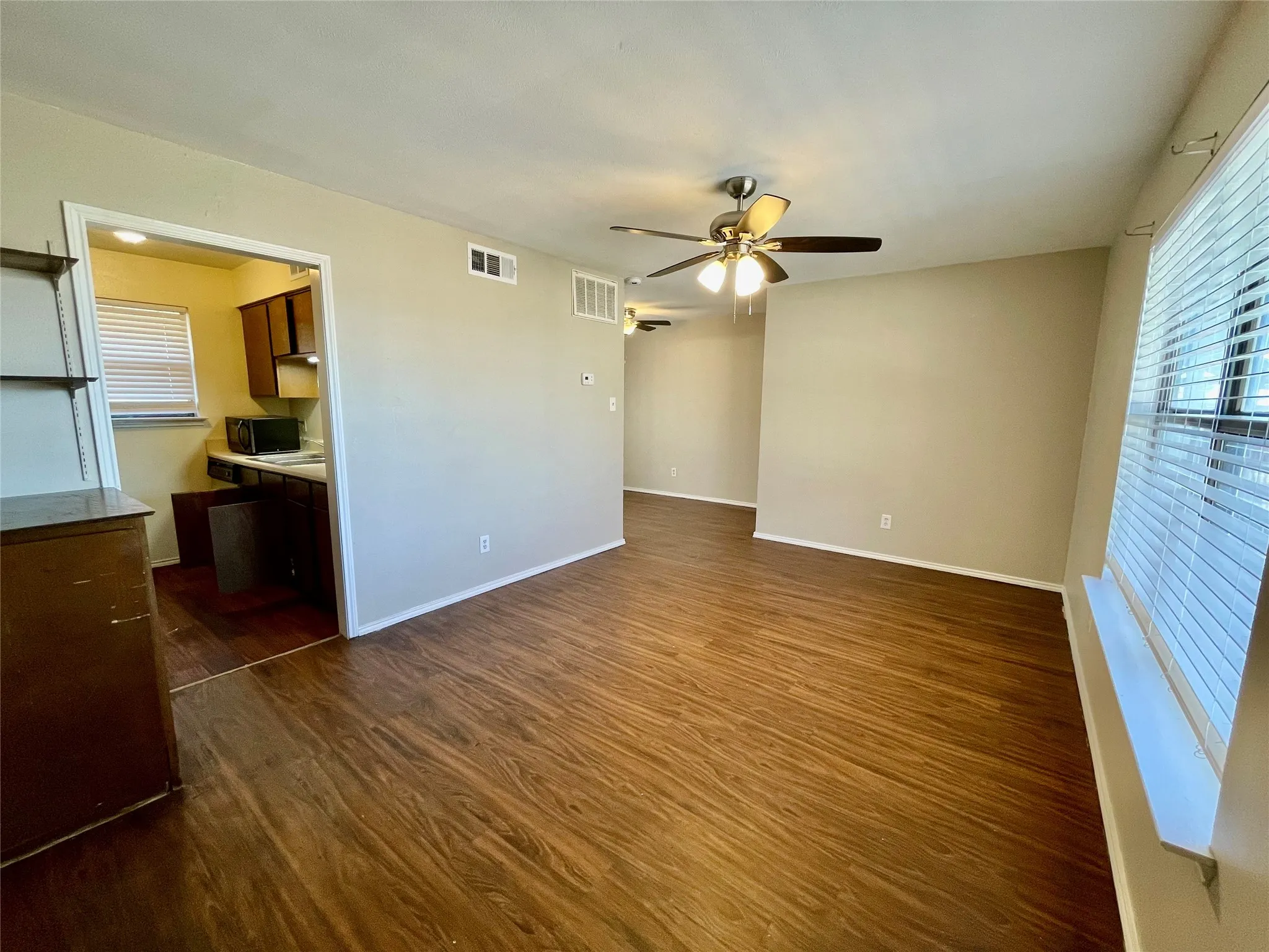 Living room. Notice the lighted ceiling fan and the beautiful flooring.