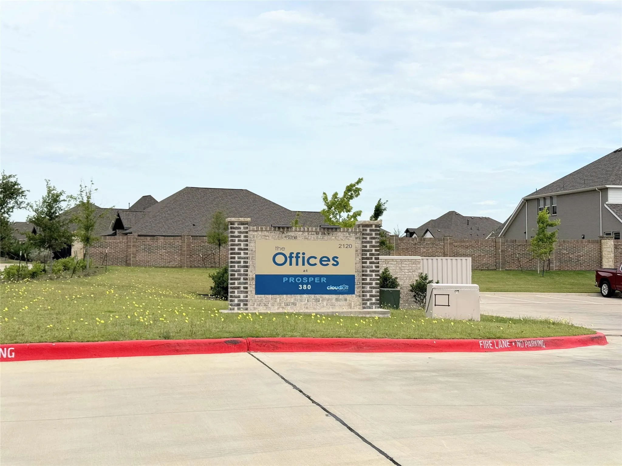 Brick and stone monument sign featuring "The Offices" branding