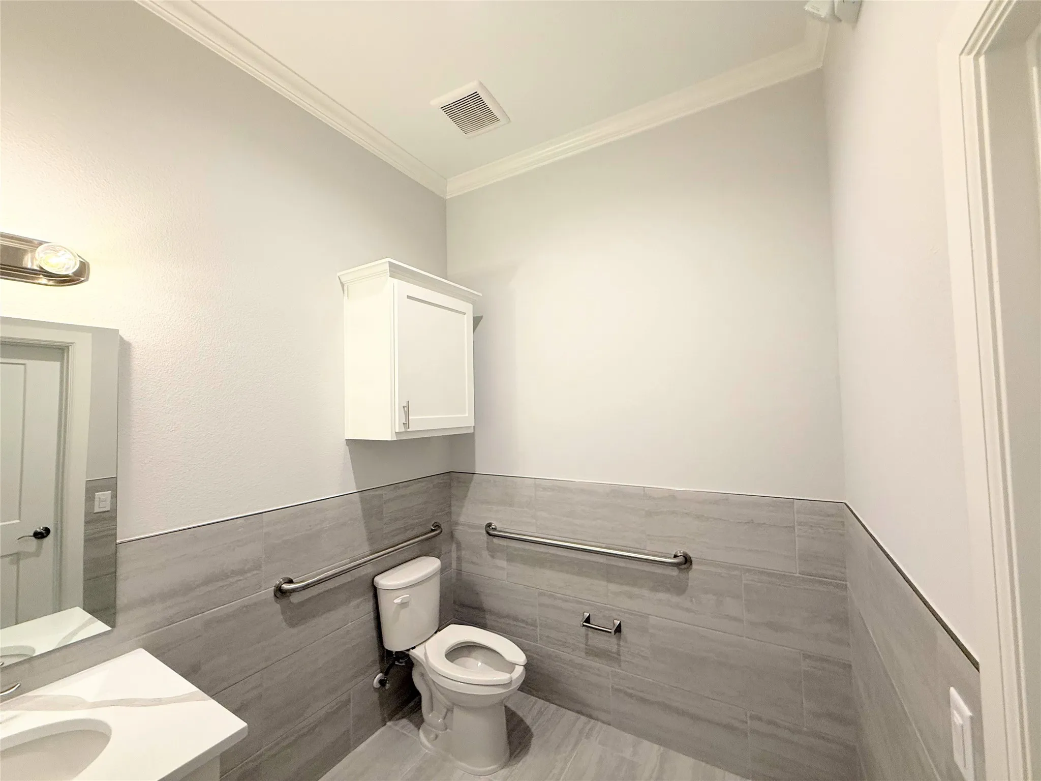 Bathroom featuring a white vanity with an integrated sink, polished chrome faucet, and quartz-finish countertop