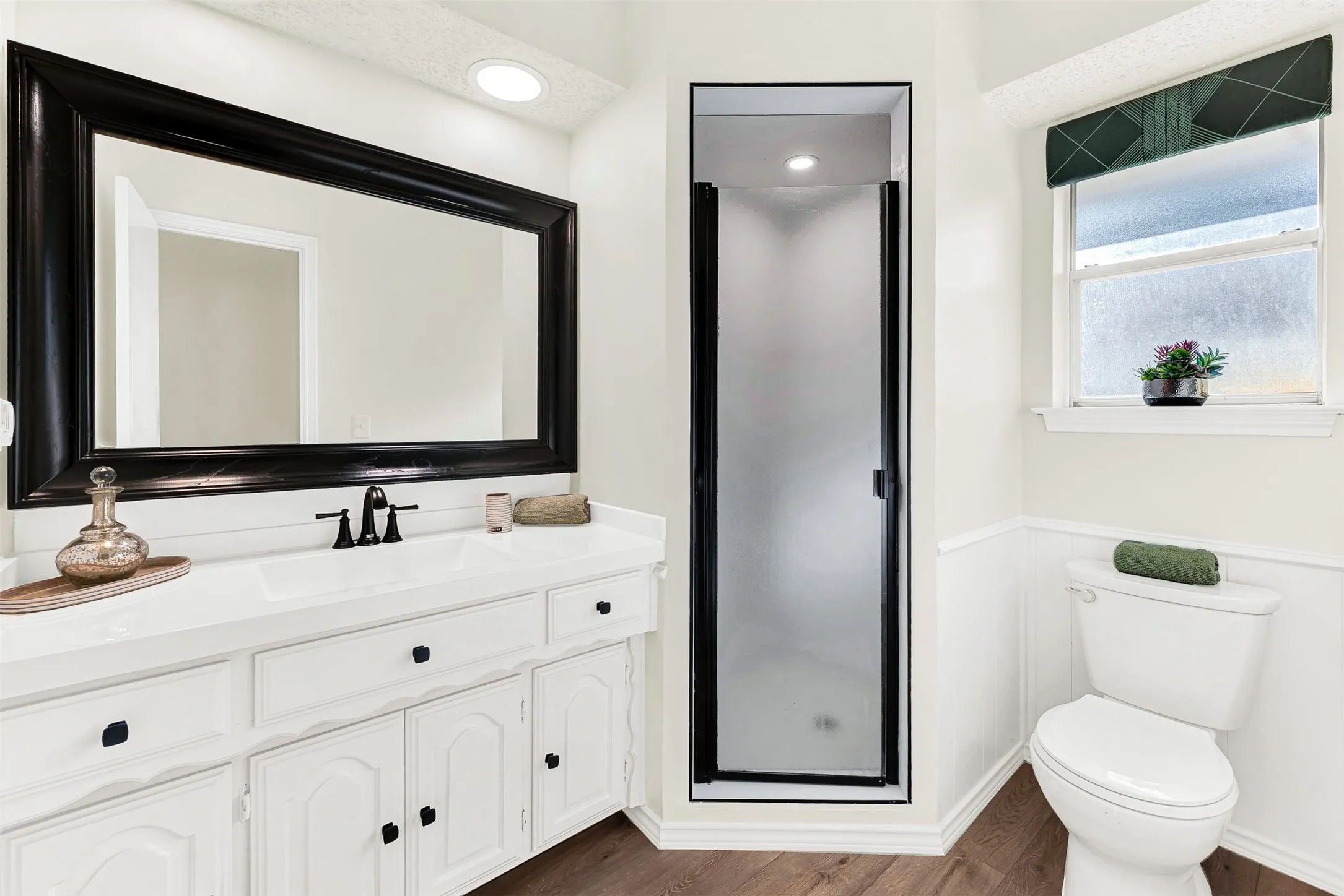 Third bathroom off the 2nd primary bedroom/ guest suite, updated with tasteful tile in shower, updated flooring and counter top, faucet.