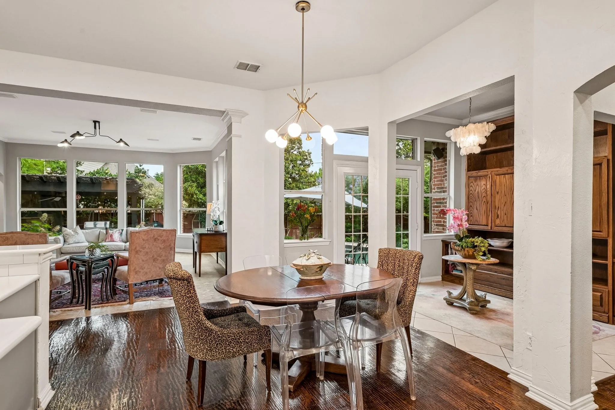 Spacious kitchen featuring wood-finish flooring, light gray cabinetry, a central island with a solid surface countertop, stainless steel appliances, and subway tile backsplash
