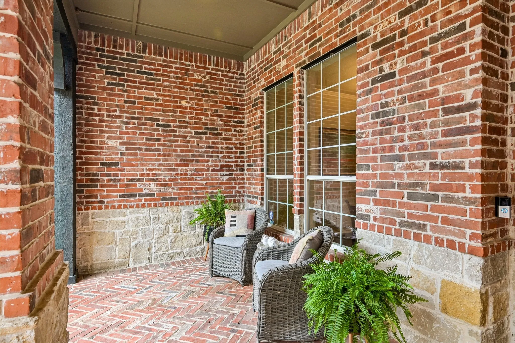 Covered patio featuring a brick and stone facade