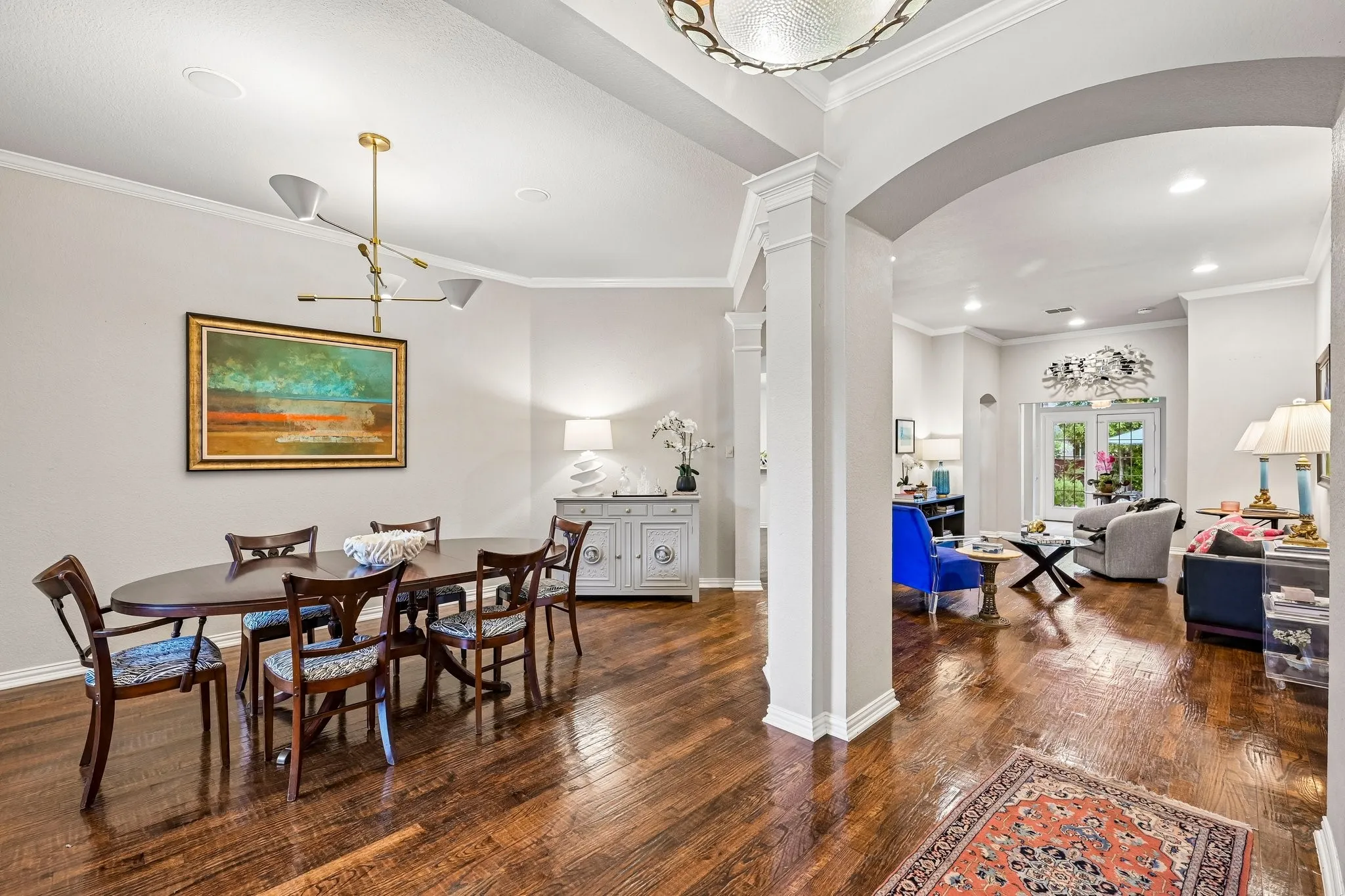 Dining area featuring wood-finish flooring, a contemporary chandelier, and recessed lighting