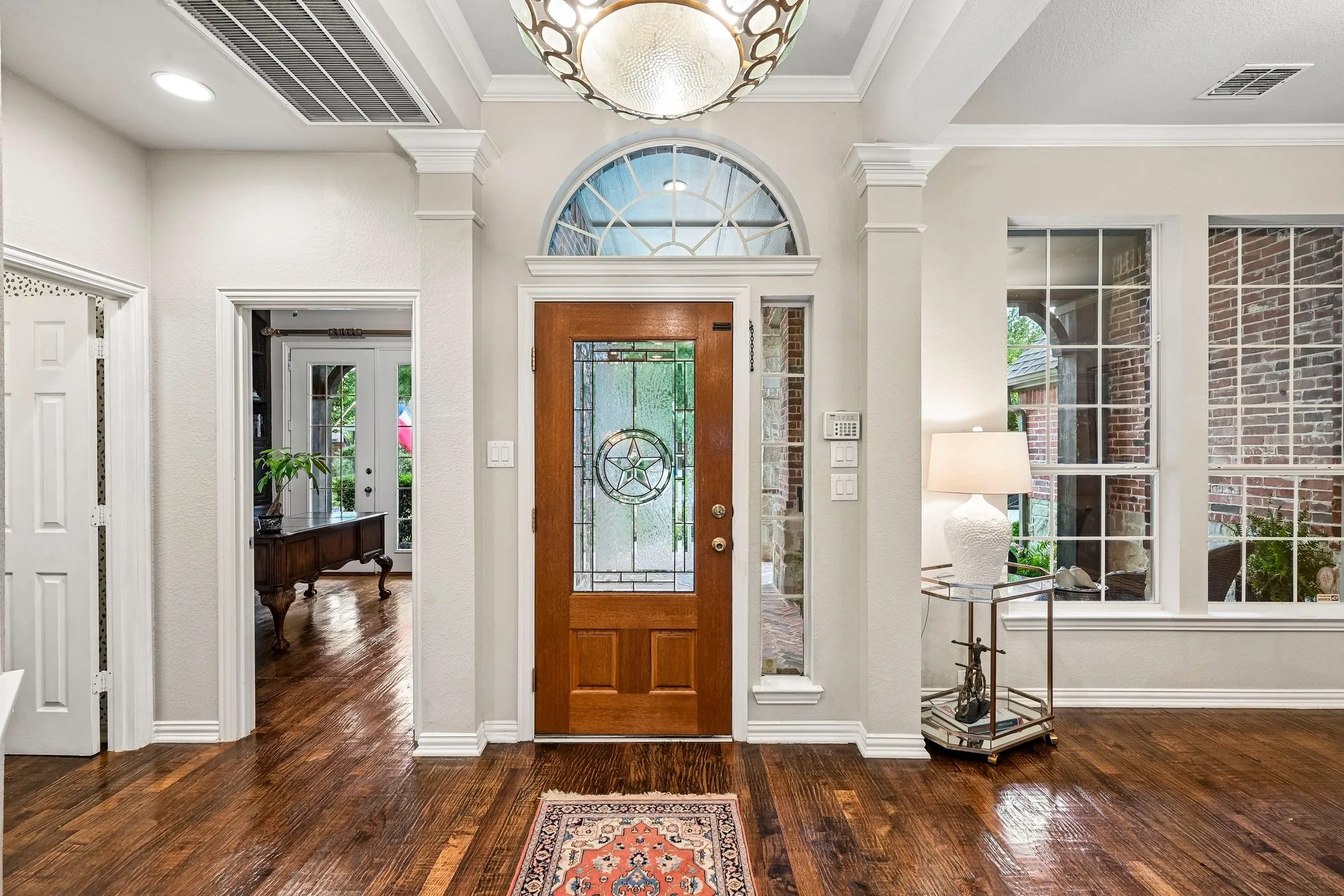 Front entry with a wood door featuring leaded glass and an arched transom window