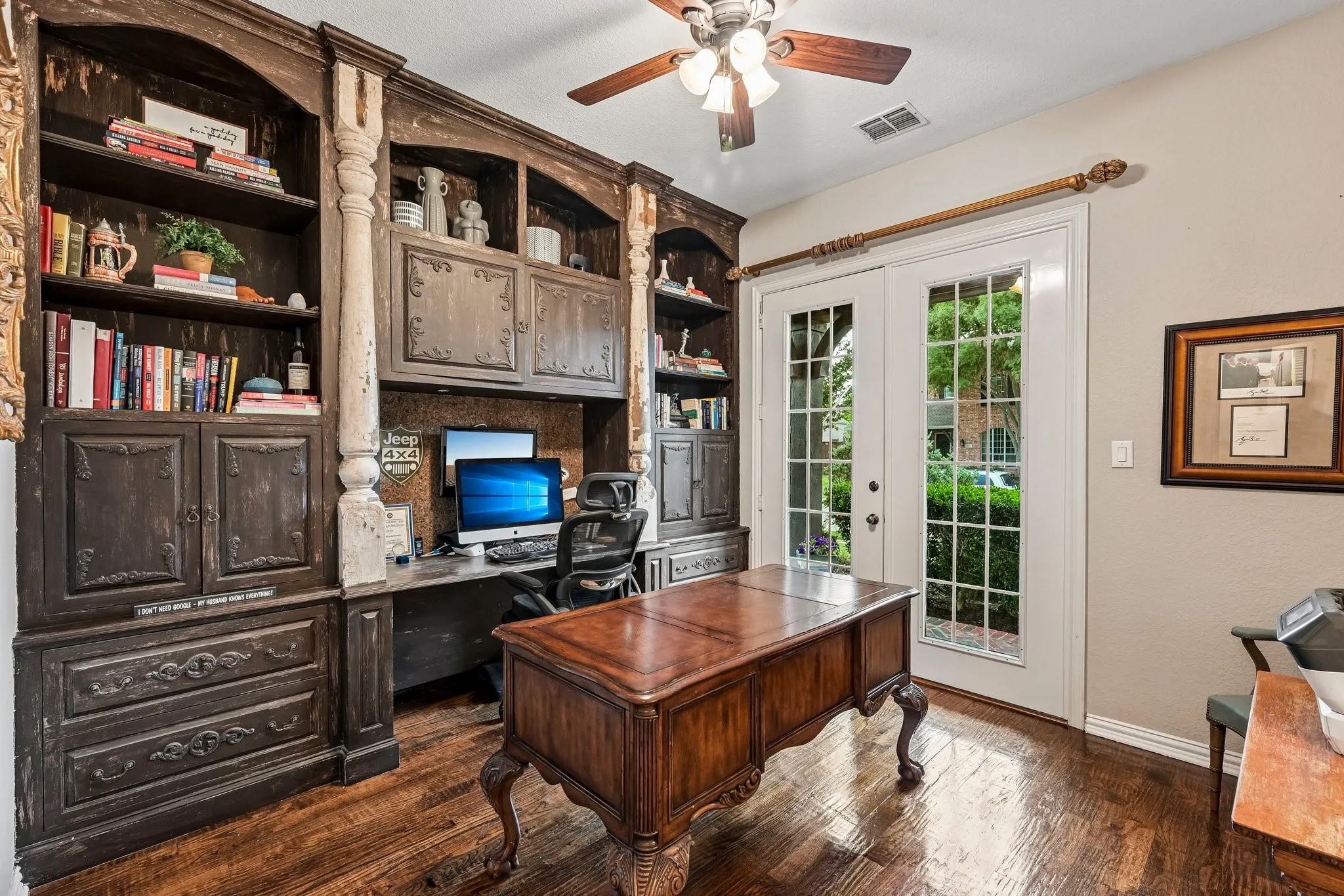 Room featuring a built-in dark wood-finish cabinet with shelving, integrated desk space, and lower storage