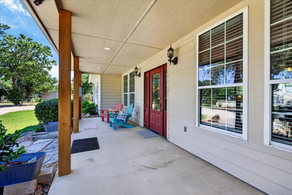 Expansive front porch featuring exposed wood support beams and a concrete surface