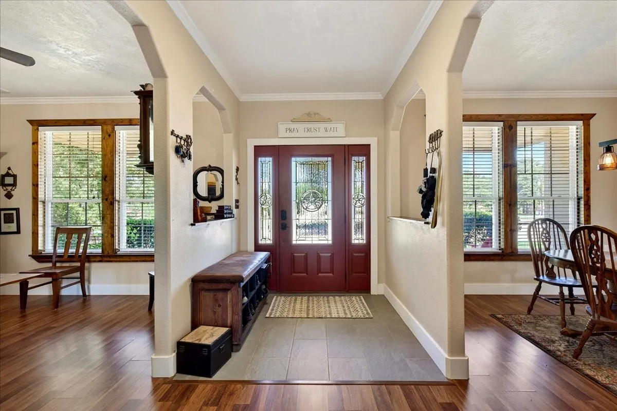 Entryway featuring a decorative transom, leaded glass sidelights, and a rich red front door. Flex space/office is on the right and Dining area is on the left.