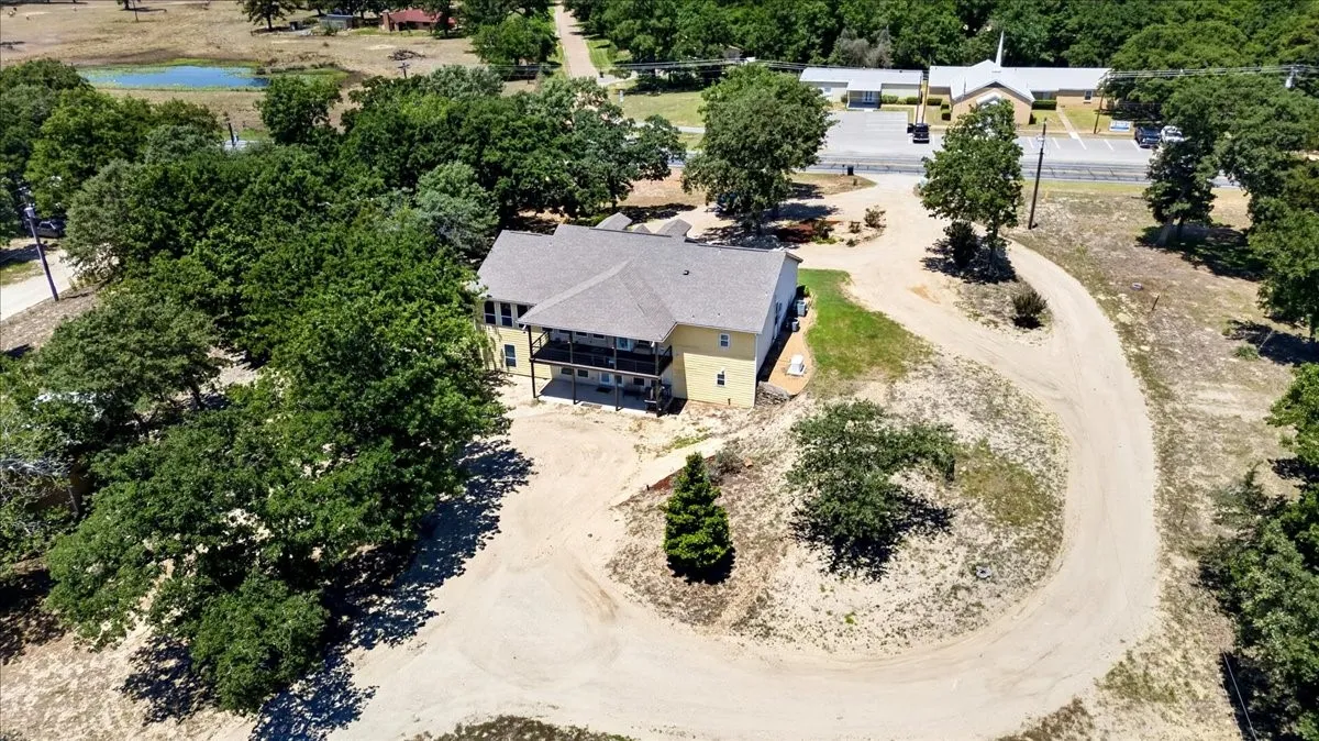 Light tan multi-level residence featuring an upper-level balcony and lower-level patio at 11591 FM 59 Athens TX 75751 in Crossroads ISD located in Henderson county of Texas.  Life is Better In The Country!!