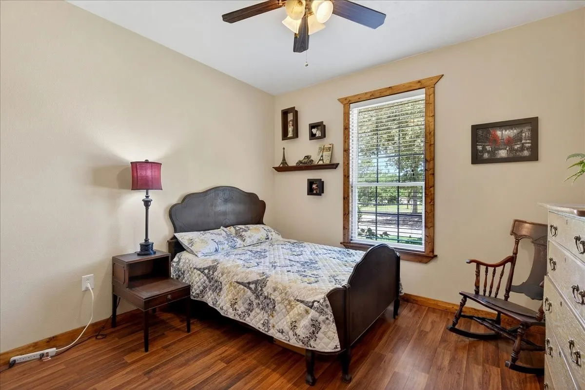 3rd Bedroom on Level 1 with Warm-toned wood-finish flooring complements the neutral wall color