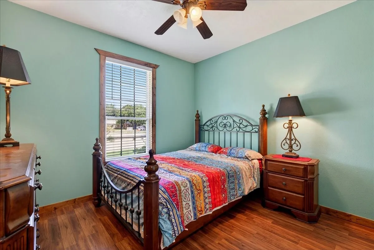 4th bedroom on Level 1 with Wood-finish flooring, ceiling fan and closet, window view.