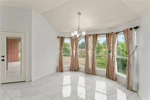 Spacious interior featuring a vaulted ceiling and a bay window with multiple panes