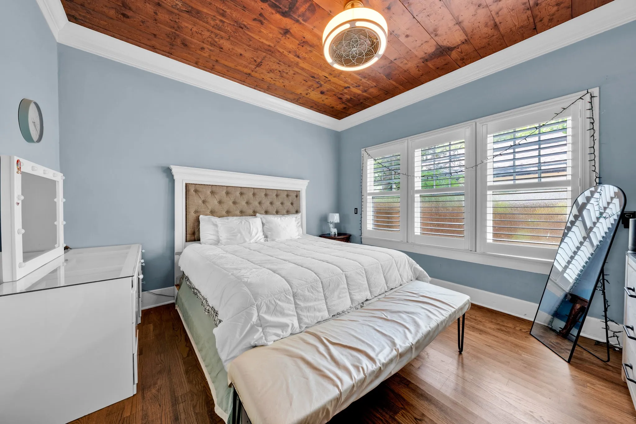 Wood-finish flooring with a distressed wood ceiling and white crown molding