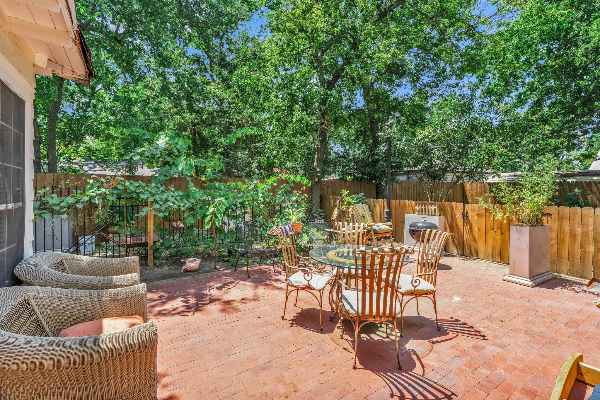 Brick paver patio with a wood privacy fence and mature trees