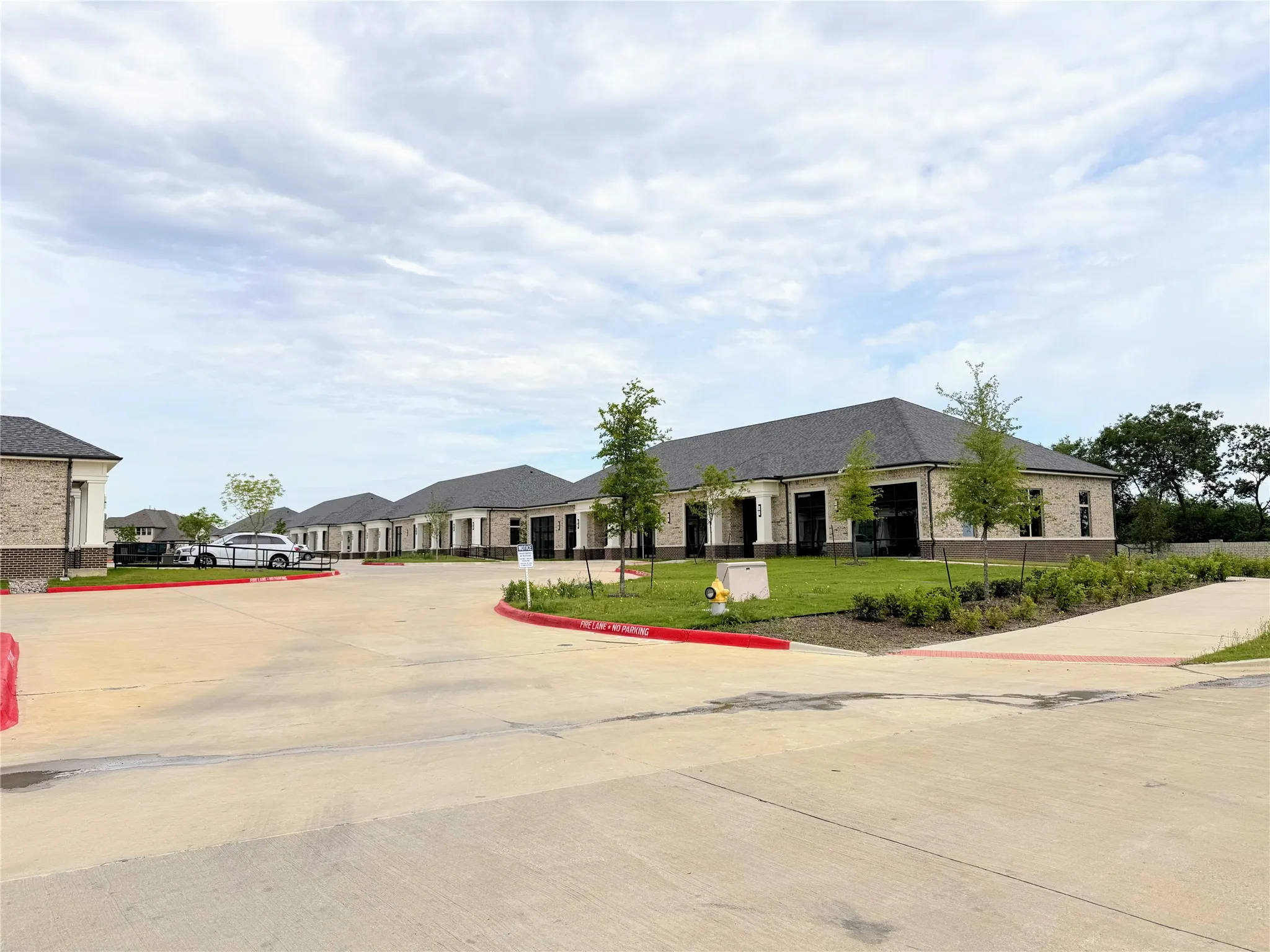 Modern architectural design featuring brick and stone facades with dark shingle roofs