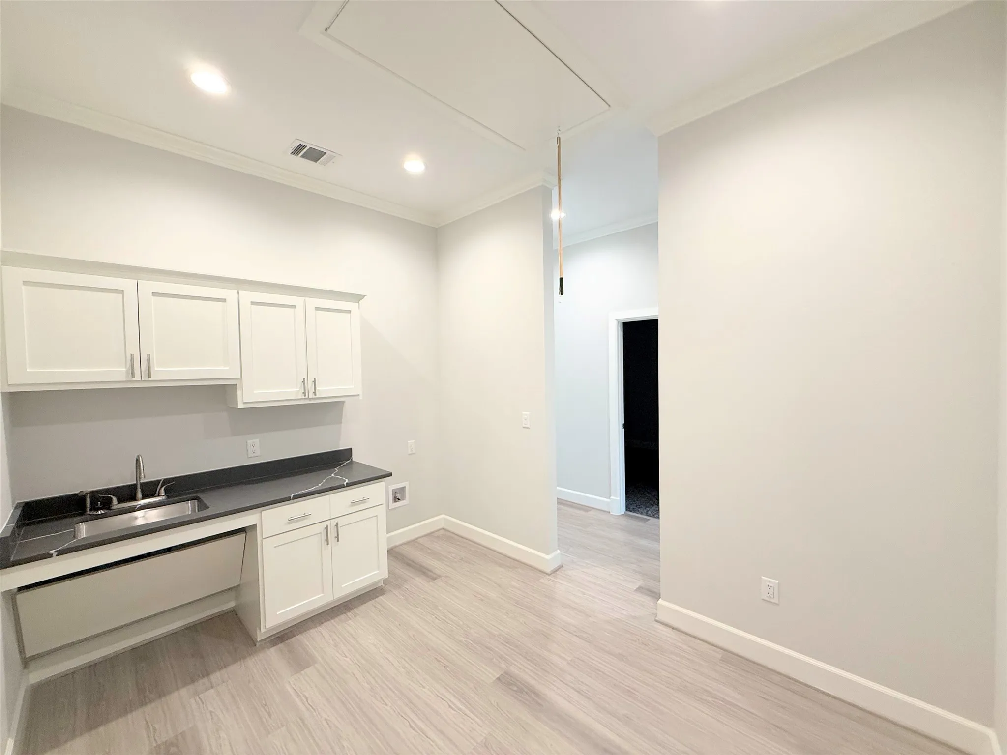 Light wood-finish flooring complements white walls and crown molding