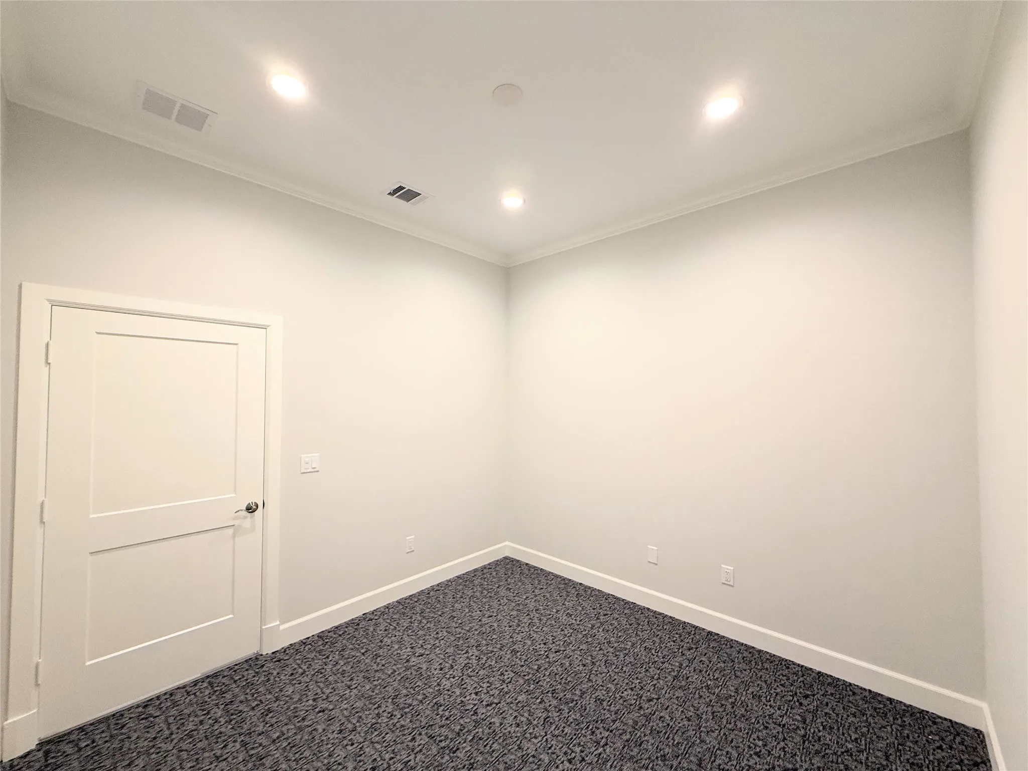 Neutral-toned room with recessed lighting and crown molding