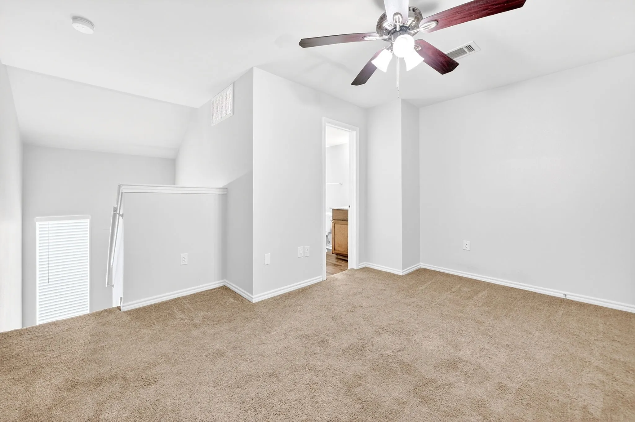Carpeted upper-level room with a ceiling fan, white walls, and white trim