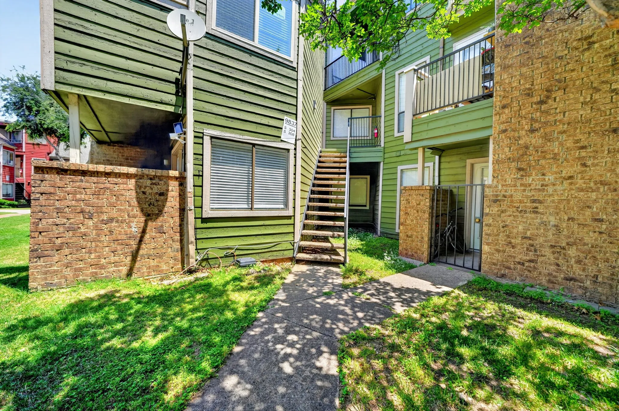 Exterior building featuring green horizontal siding and brick accents