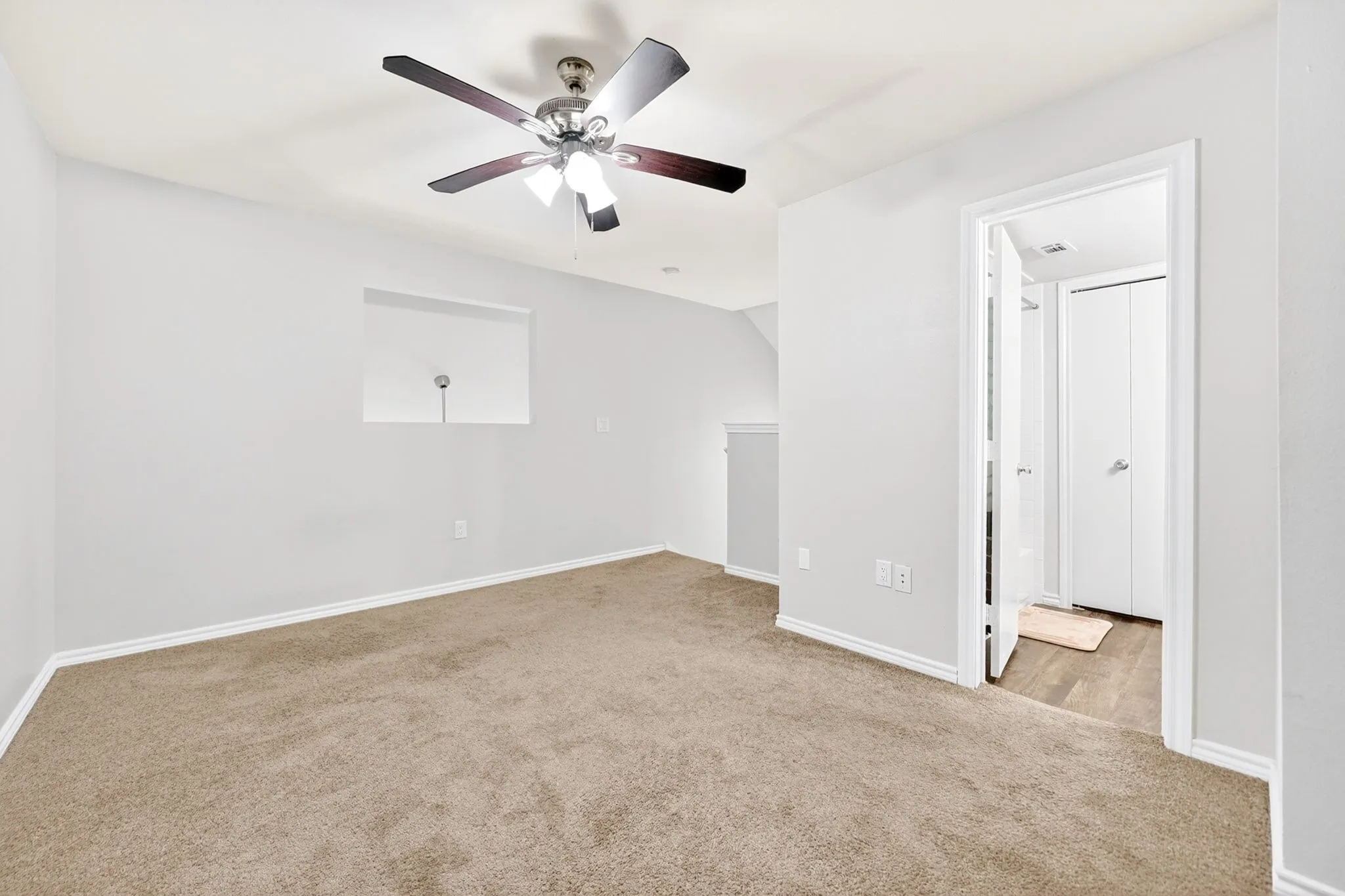 Neutral tone wall finishes with a ceiling fan featuring wood-finish blades and integrated lighting