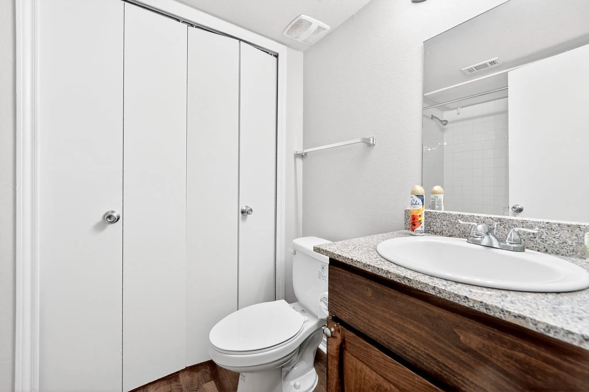 Bathroom vanity featuring a speckled countertop, integrated sink, and wood-finish cabinetry