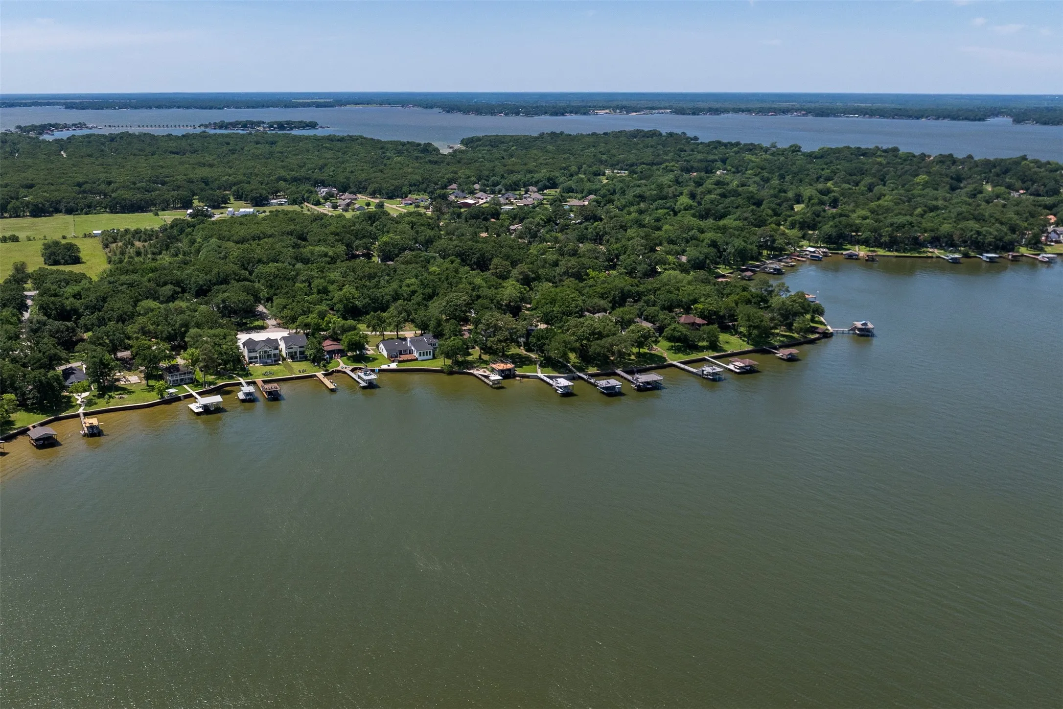 Waterfront properties featuring private boat docks and dense surrounding tree cover