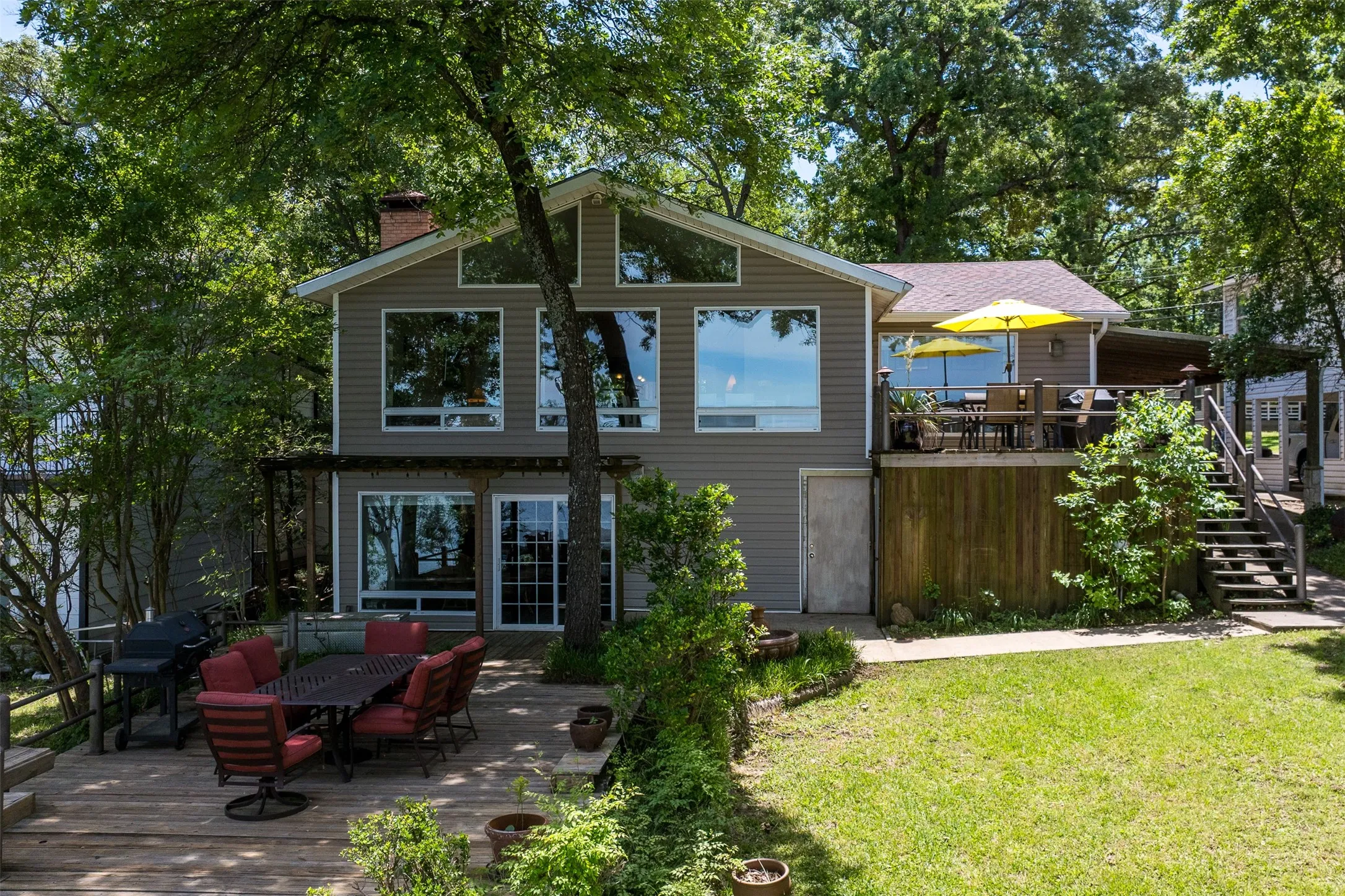 Multi-level residence featuring a gray siding exterior and an abundance of windows