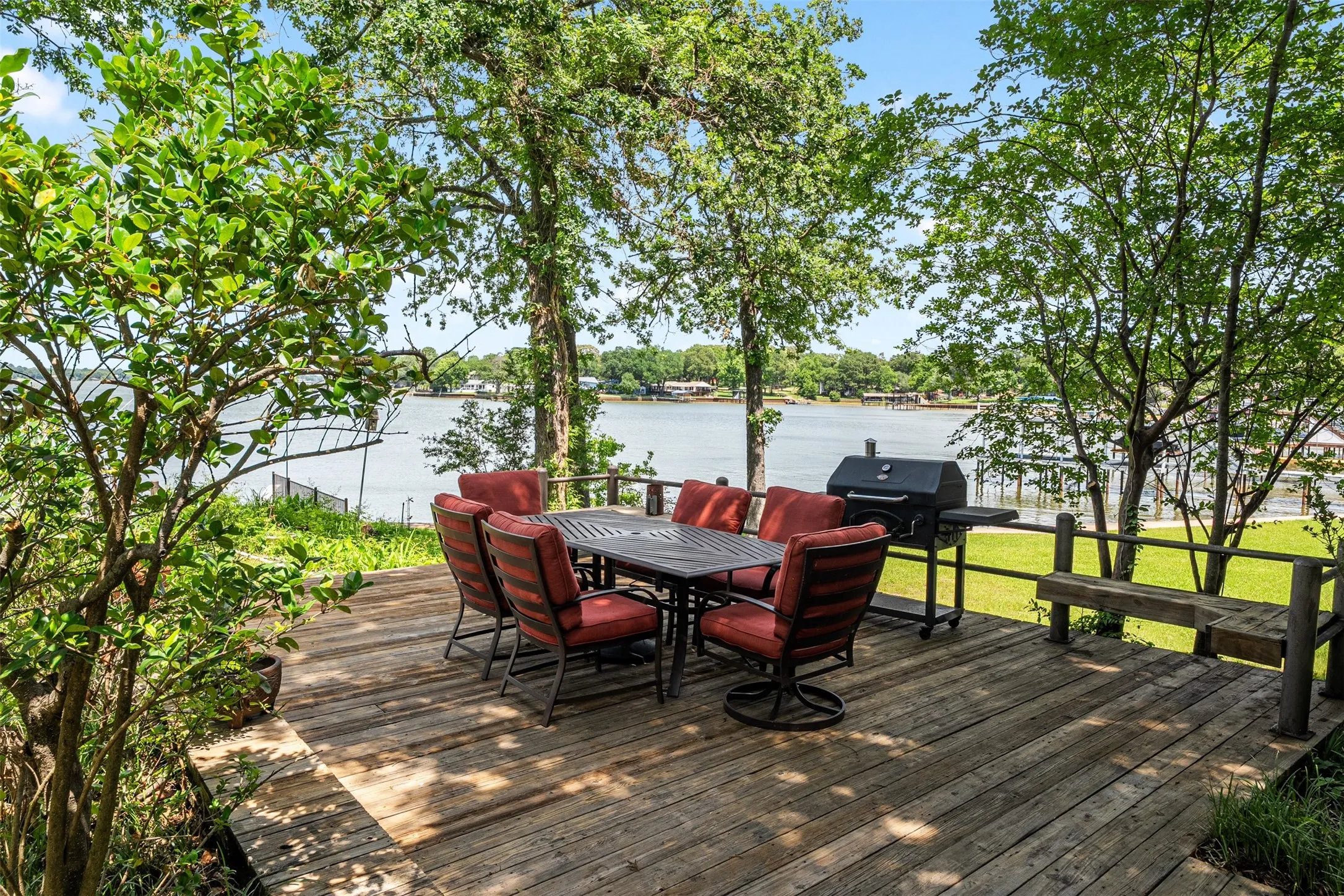 Expansive wood deck with a built-in bench, offering a waterfront setting