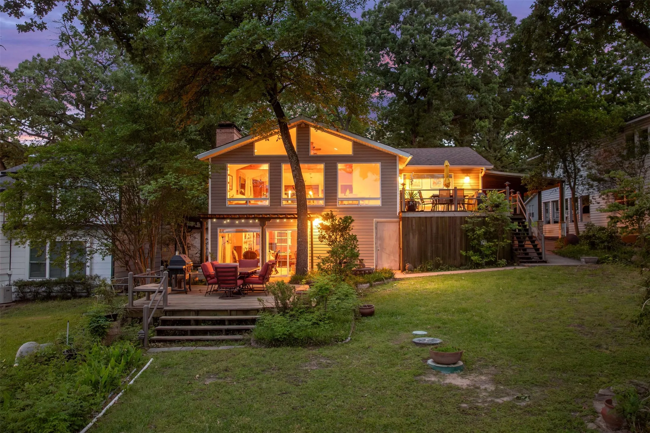 Contemporary two-story residence with a multi-level deck, featuring a gabled roofline and a lower-level walkout
