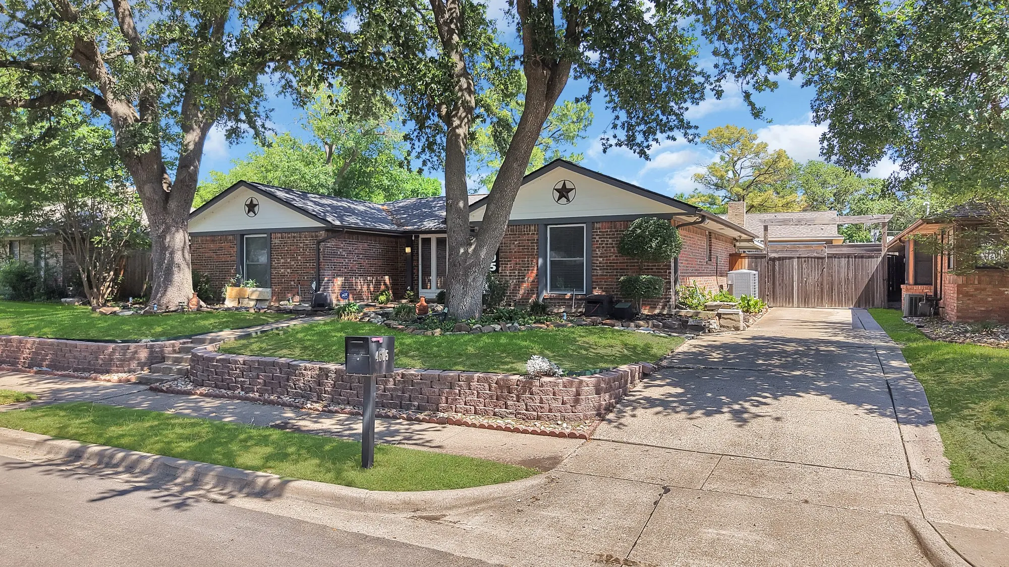 Brick exterior residence with a concrete driveway and an expansive front lawn