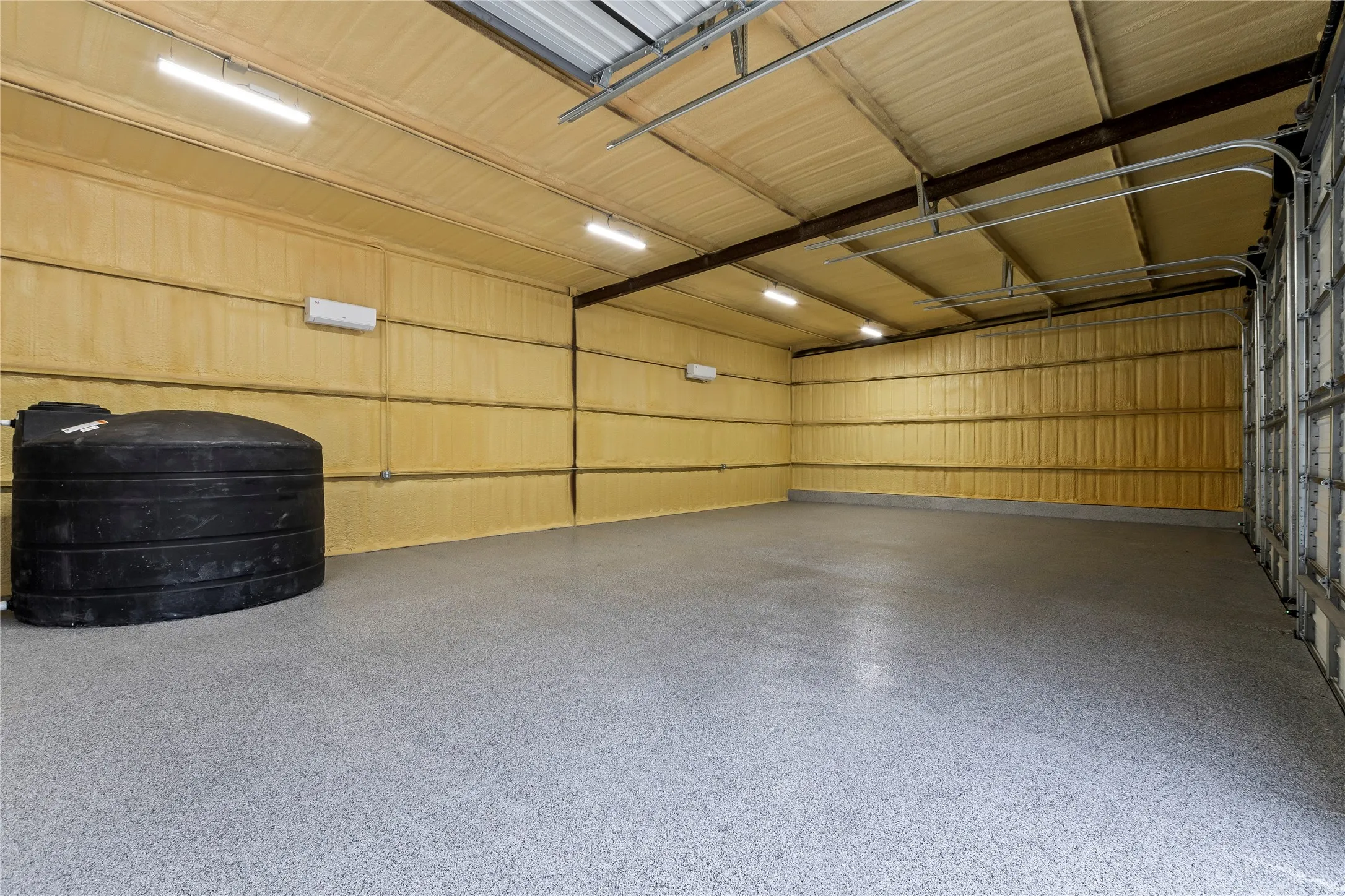 Interior of the 4 Bay Shop. Insulated w/ Spray Form and Climate Controlled. Perfect for the car collector or turn it into a huge game room! Pictures is the 1550 gal fresh water storage tank.